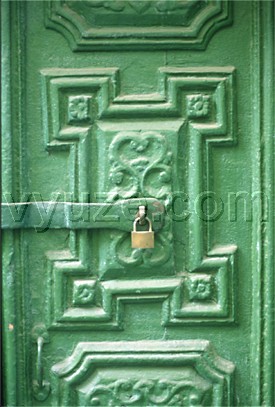 Green painted door with carving and padlock / Location: Metsovo, Epirus, Greece